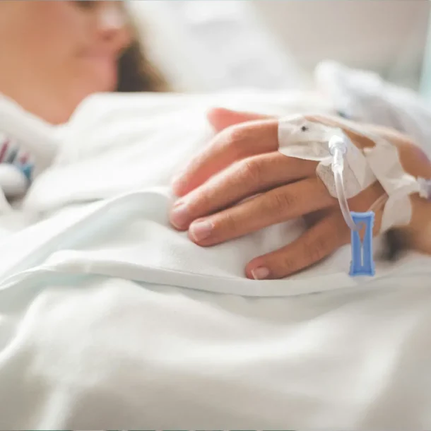 Close-up of a hospital patient's hand with medical devices attached